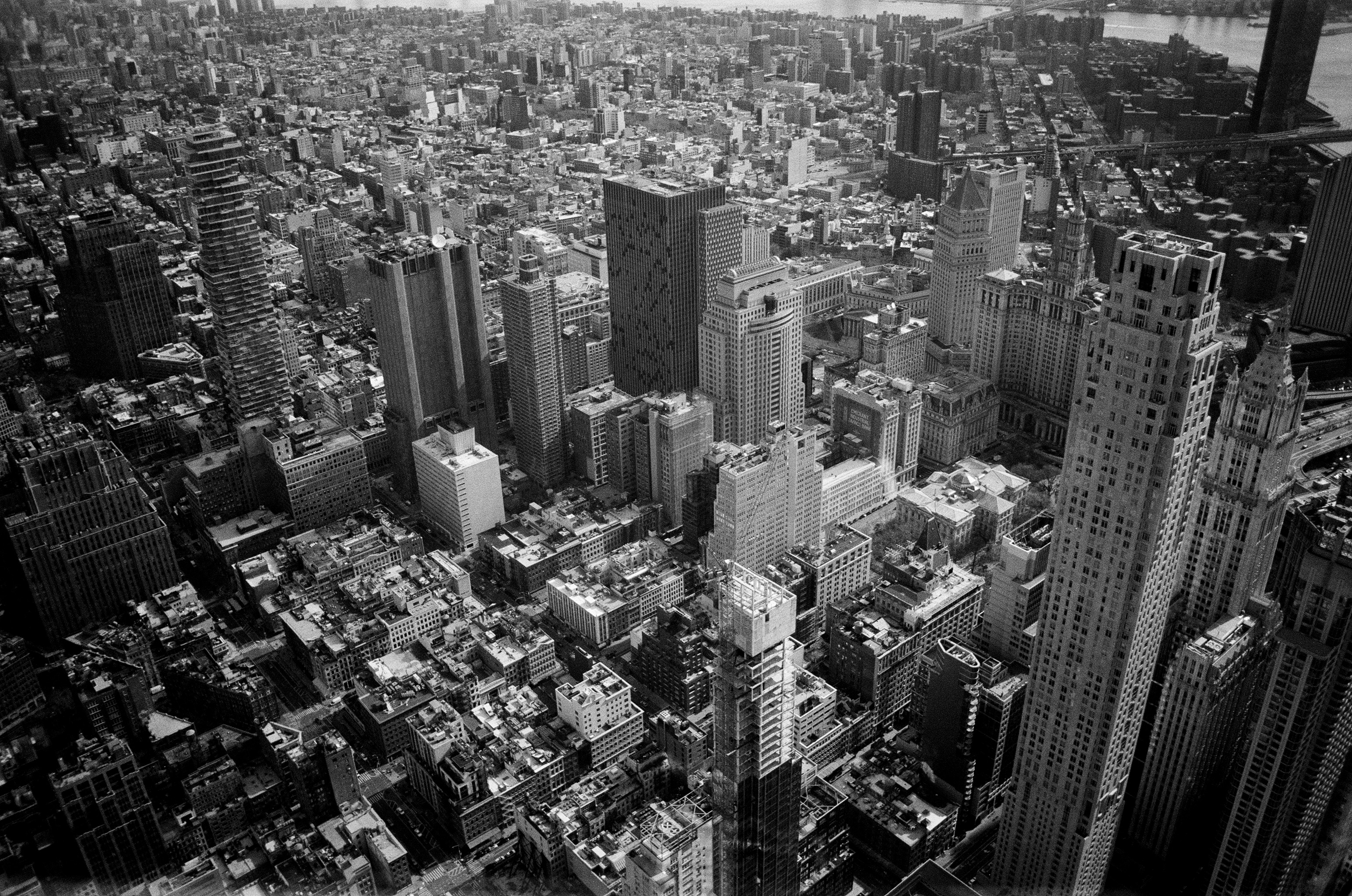 A black and white photograph of downtown Manhattan in New York taken from One World Trade Center.